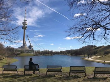 People sitting on bench by lake