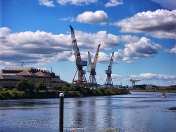 Commercial dock by river against sky