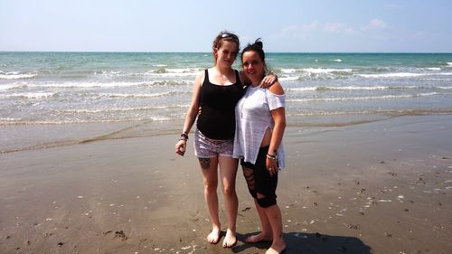 Full length of young woman standing on beach