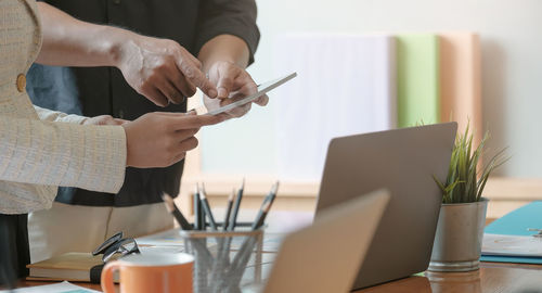 Business colleagues using digital tablet at office