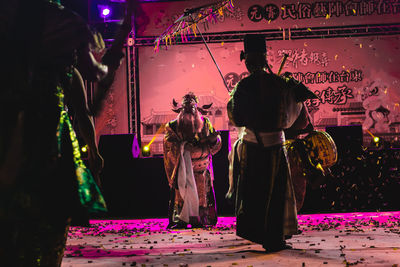 Rear view of people at illuminated shop