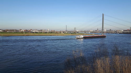 View of suspension bridge over river against sky