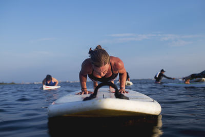 Full length of young woman in sea against sky