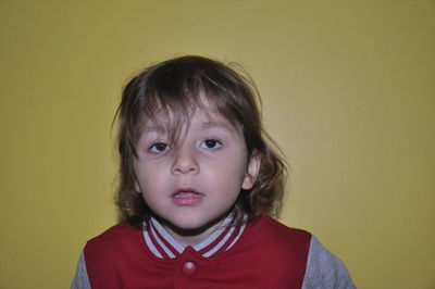 Portrait of cute boy against yellow background