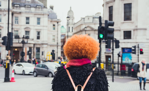 Rear view of woman wearing wig on street in city