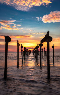 Pier over sea against sky during sunset