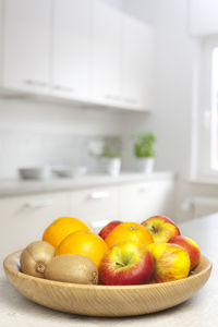 Fruits in bowl on table at home