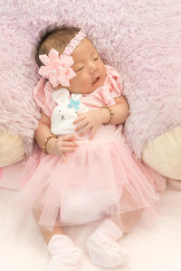 High angle view of cute baby girl sleeping on bed