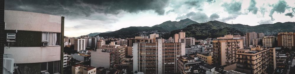 Panoramic view of buildings against cloudy sky