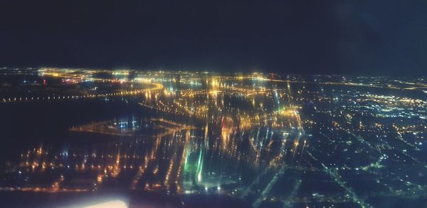 Illuminated cityscape against sky at night