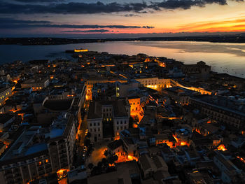 High angle view of illuminated city at sunset