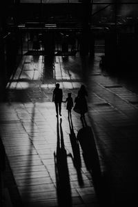 Rear view of people walking on floor in city
