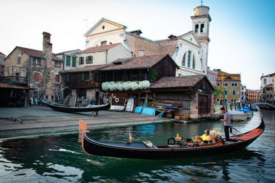 Boats in canal amidst buildings in city