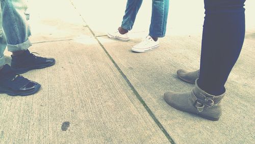 Low section of people standing on tiled floor