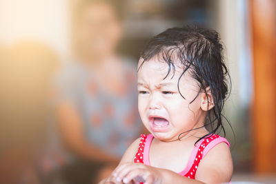 Wet baby girl crying at home