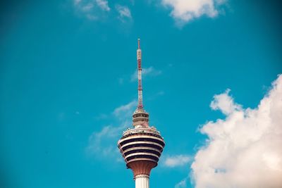 Low angle view of communications tower against cloudy sky