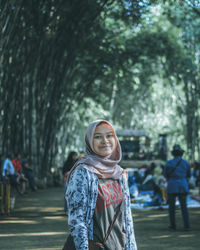 Teenage girl wearing hijab looking away while standing in city