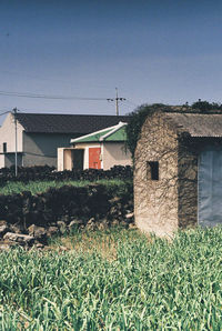 Houses on field against clear sky