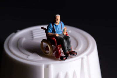Elderly senior citizen sitting in a wheelchair that is on a medicine bottle healthcare insurance