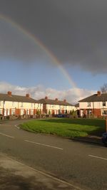 Rainbow over residential buildings against sky