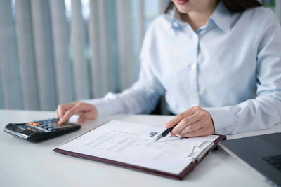 Midsection of woman working on table