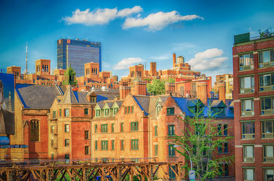 Buildings in city against cloudy sky