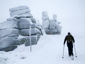 Man standing in snow against clear sky