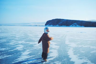 Full length of boy in sea against blue sky