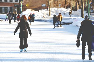 People ice-skating on snow covered field