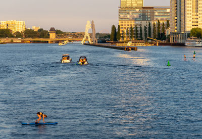 Mature woman paddleboarding on river against sky during sunset