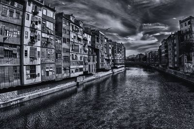 Buildings in city against cloudy sky