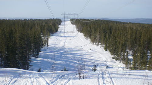 Scenic view of snowy field against sky during winter