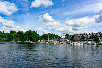 Scenic view of river by buildings against sky