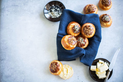 Homemade sweet yeasty buns with sugar and seeds on linen napkin. close up.