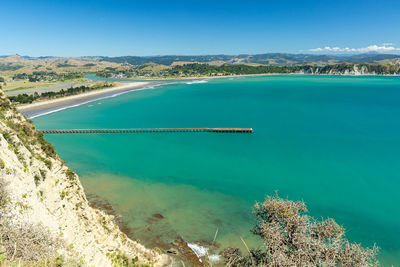 A photo of tolaga bay wharf in new zealand. scenic view from the hill. 