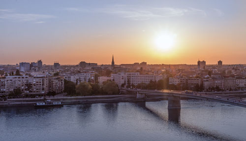 View of buildings at waterfront during sunset