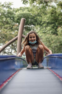 Portrait of girl crouching outdoors