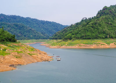 Scenic view of river by mountains against sky