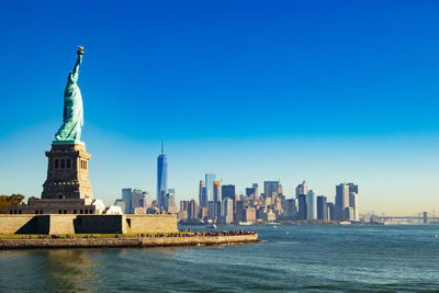 Statue of buildings in city against clear sky