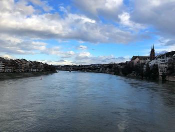 Scenic view of river by buildings against sky
