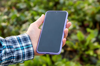 Cropped hand of woman using mobile phone