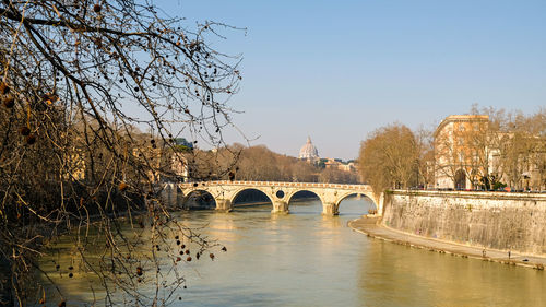 Arch bridge over river against sky