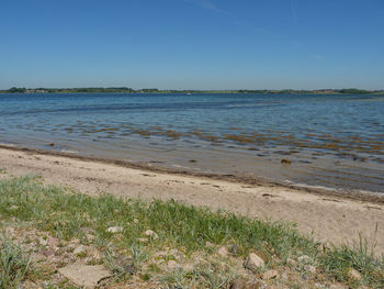 Scenic view of sea against clear blue sky