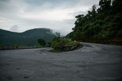 Road amidst trees against sky