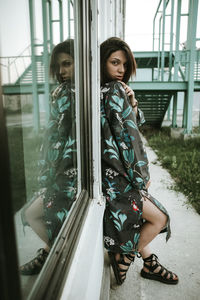 Young woman sitting on window