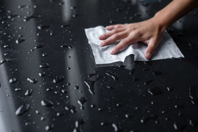 Close-up of woman touching wet glass