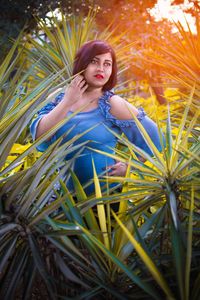 Portrait of beautiful young woman on plant