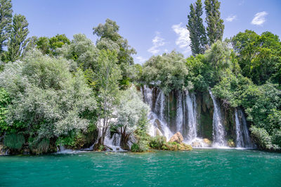 Scenic view of waterfall against sky
