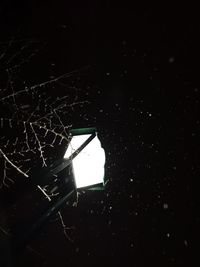 Low angle view of illuminated lighting equipment in darkroom