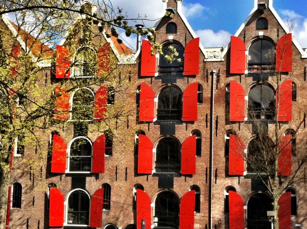 architecture, building exterior, built structure, arch, place of worship, religion, church, spirituality, low angle view, sky, red, facade, day, outdoors, window, cross, entrance, tree